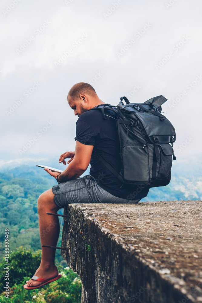 Poster male hiker with backpack sitting on top with beautiful scenery on asia environment with green vegeta