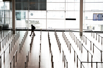 silhouette of a person walking through the empty airport hall