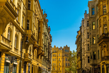 A view along a street of ornate buildings leading from the old town square in central Prague in springtime