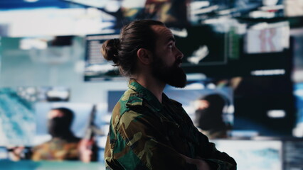 Young veteran reviewing battlefield data in a high tech command center, ensuring war planning...