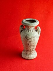 Antique ceramic decorative amphora on red background. Clay pot, set of antique utensils for gardening and interior. Back view