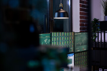 Quiet, dark office with multiple monitors displaying charts, creating an atmosphere of anticipation...