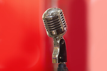Vintage microphone on stage on a red background