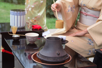 Woman in kimono performs Japanese tea ceremony