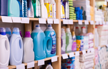 Assorted bottles of detergents and cleaning supplies neatly displayed for customers on shelves of...