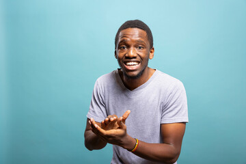 African american man with proud expression leaning forward and clapping his hands, happy with the...
