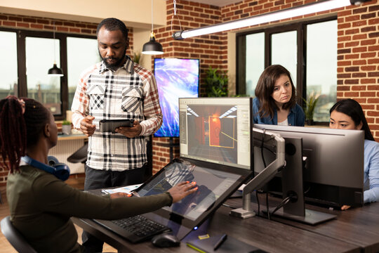 Multiethnic colleagues utilizing digital technology during their creative brainstorming session in modern workspace. Diverse team of employees working together in developing project designs in office.