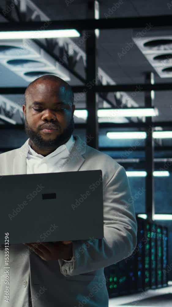 Poster vertical video engineer walking in data center using ai automation during maintenance session. afric