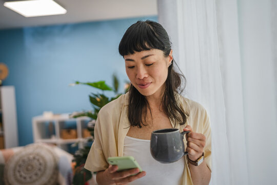 Morning routine of japanese woman drink coffee and use mobile phone - Powered by Adobe