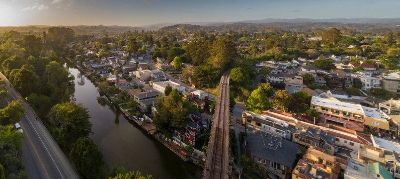 Aerial panorama of a California town of Capitola, USA, showing the river, train tracks, and residential area, highlighting the unique layout.  California, United States