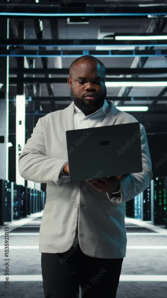 Poster vertical video programmer in data center using laptop, testing equipment failover scenarios. server 