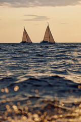 Sailing regatta in the Gulf of Finland at sunset, two sailing yachts competing in a race, splashing...