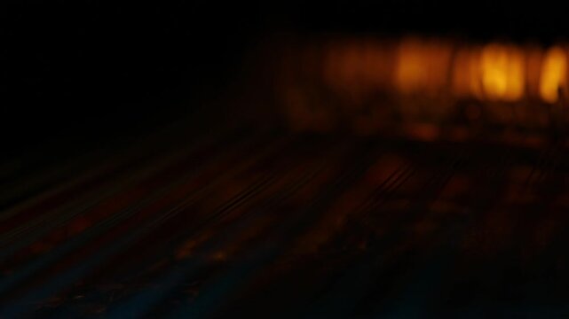 A cinematic rack focus travels down the strings of a traditional ethnic lute, possibly an Oud. Moody blue and orange lights create a mysterious, artistic closeup.