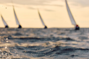 Sailing regatta in the Gulf of Finland at sunset, few sailing yachts competing in a race, splashing...
