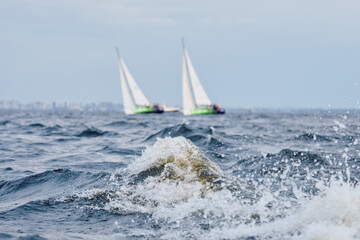 Sailing regatta in the Gulf of Finland at sunset, sailing yacht competing in a race, splashing...