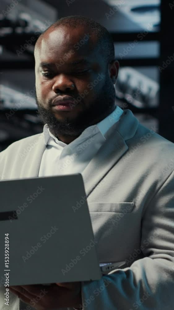 Poster vertical video data center computer scientist using laptop to manage system stability. server room i