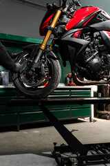 Mechanic performs front suspension service on motorcycle, adjusting forks for precision handling....