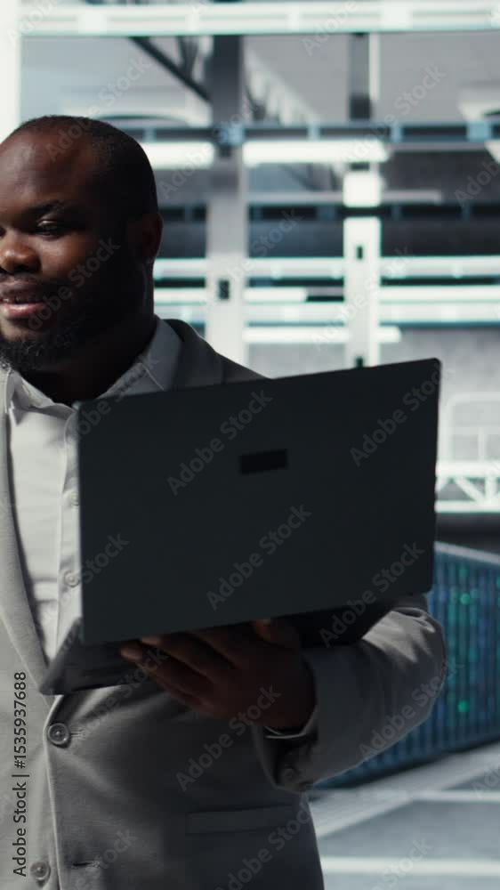 Poster vertical video technician walking in data center, configuring storage devices for minimal latency in