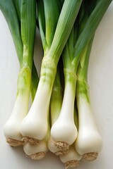 Fresh leeks with white bulbs and green stalks isolated on white background