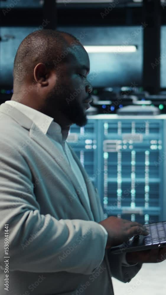 Aufkleber vertical video manager overseeing server room, walking around with checklist on laptop, troubleshoot