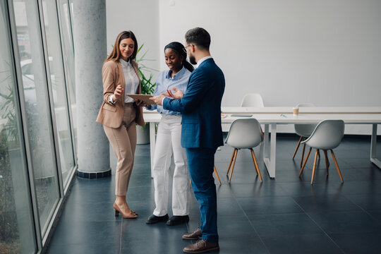 Business people discussing work using tablet in modern office