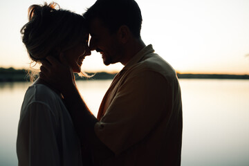 Romantic couple embracing at sunset by the lake