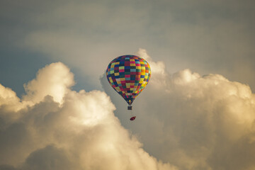 Colorful Hot Air Balloon Flying Above Clouds at Sunset Sky