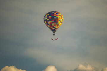 Colorful Hot Air Balloon Flying Above Clouds at Sunset Sky