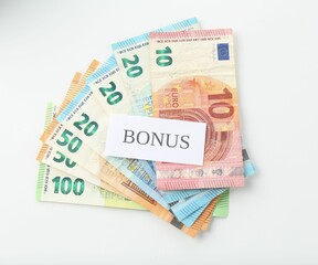 Euro banknotes and card with word Bonus isolated on white, top view