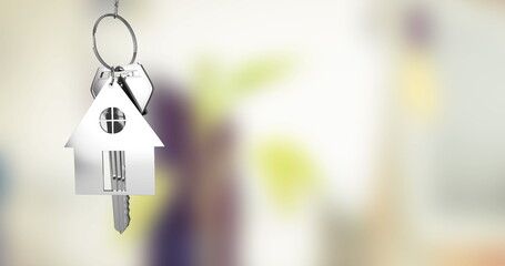 Hanging silver house-shaped keychain from metal keyring with keys inside home entryway, copy space