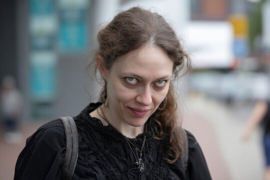 Woman on a street with a creepy smirk face