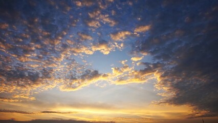 Beautiful cotton-like clouds are highlighted by the yellow afternoon sun, perfect for a background