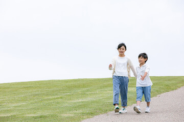Obraz premium 丘の上を笑顔で歩く子ども 