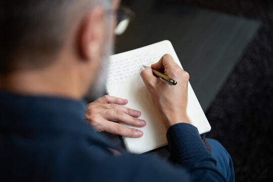 Senior Man Writing in Notebook Journaling Personal Thoughts Reflections