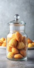 Mini madeleines stacked in a glass jar