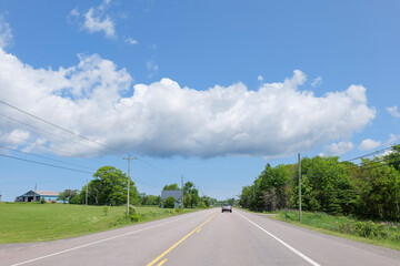 summer road view with blue sky and clouds, prince edward island Canada