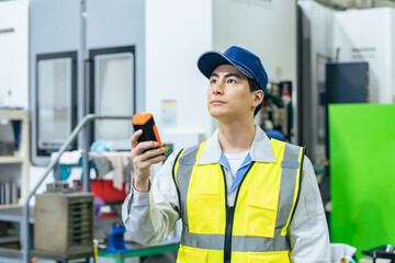 工場でポータブル測定器を使う作業員