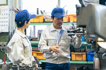 工場で工作機械を操作する作業員グループ