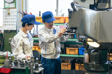 工場で工作機械を操作する作業員グループ