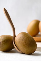 Fresh kiwi fruit with wooden spoon on white background, Healthy eating