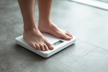 Fototapeta premium Man Weighing Himself on a Modern Digital Bathroom Scale Healthy Lifestyle Weight Management Wellness Body Care Personal Health Scale Measurement Fitness Routine Weight Control Self