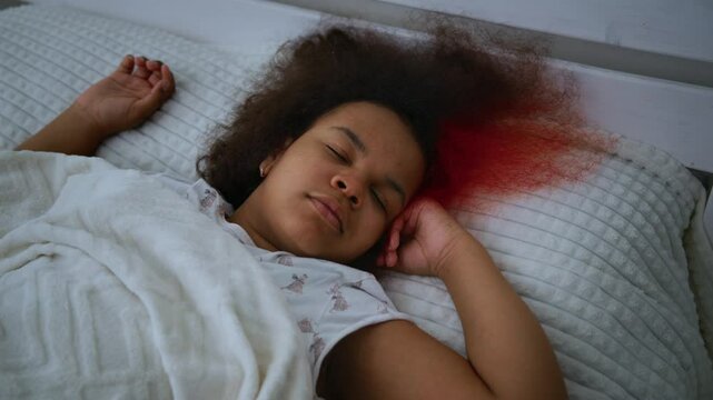 Young woman resting motionlessly, dark red substance spreading silently across white pillow, suggesting potential medical emergency or mysterious health crisis