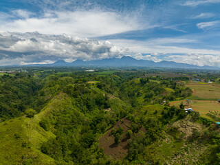 Obraz premium Green mountain valley and rainforest. Blue sky and clouds. Mindanao, Philippines.