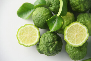 Kaffir lime or bergamot fruit, Kaffir lime or citrus hystrix fruit sliced and decorated with leaves on a white background