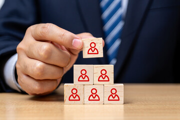 Businessman Building a Team Hierarchy with Wooden Blocks