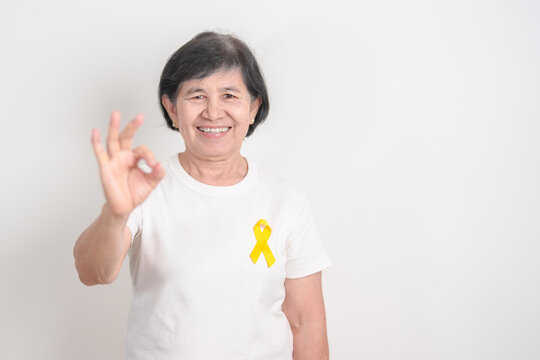 Elderly with Yellow Ribbon for concept of yellow September, Suicide prevention day, Childhood, July Sarcoma, bone cancer Awareness in children month, support survivor. Healthcare and World Cancer day