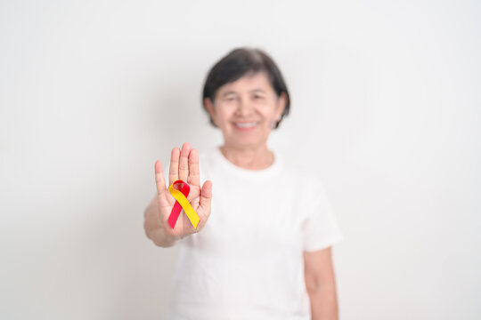 World hepatitis day awareness month, 28 July. elderly woman with Red and Yellow ribbon. Liver cancer, Jaundice, Cirrhosis, Failure, Enlarged, Hepatic Encephalopathy and Health concept