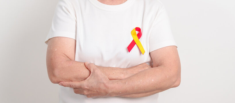World hepatitis day awareness month, 28 July. elderly woman with Red and Yellow ribbon. Liver cancer, Jaundice, Cirrhosis, Failure, Enlarged, Hepatic Encephalopathy and Health concept