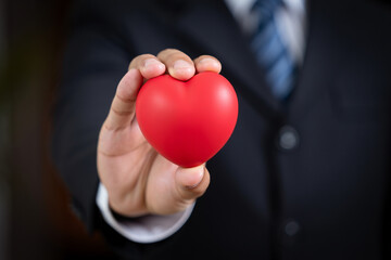 Businessman Holding Red Heart Shape Representing Love Care and Compassion