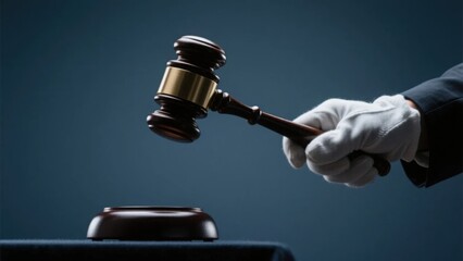 A hand wearing a white glove swings a gavel, symbolizing judicial judgment and conveying a solemn and authoritative legal atmosphere.
